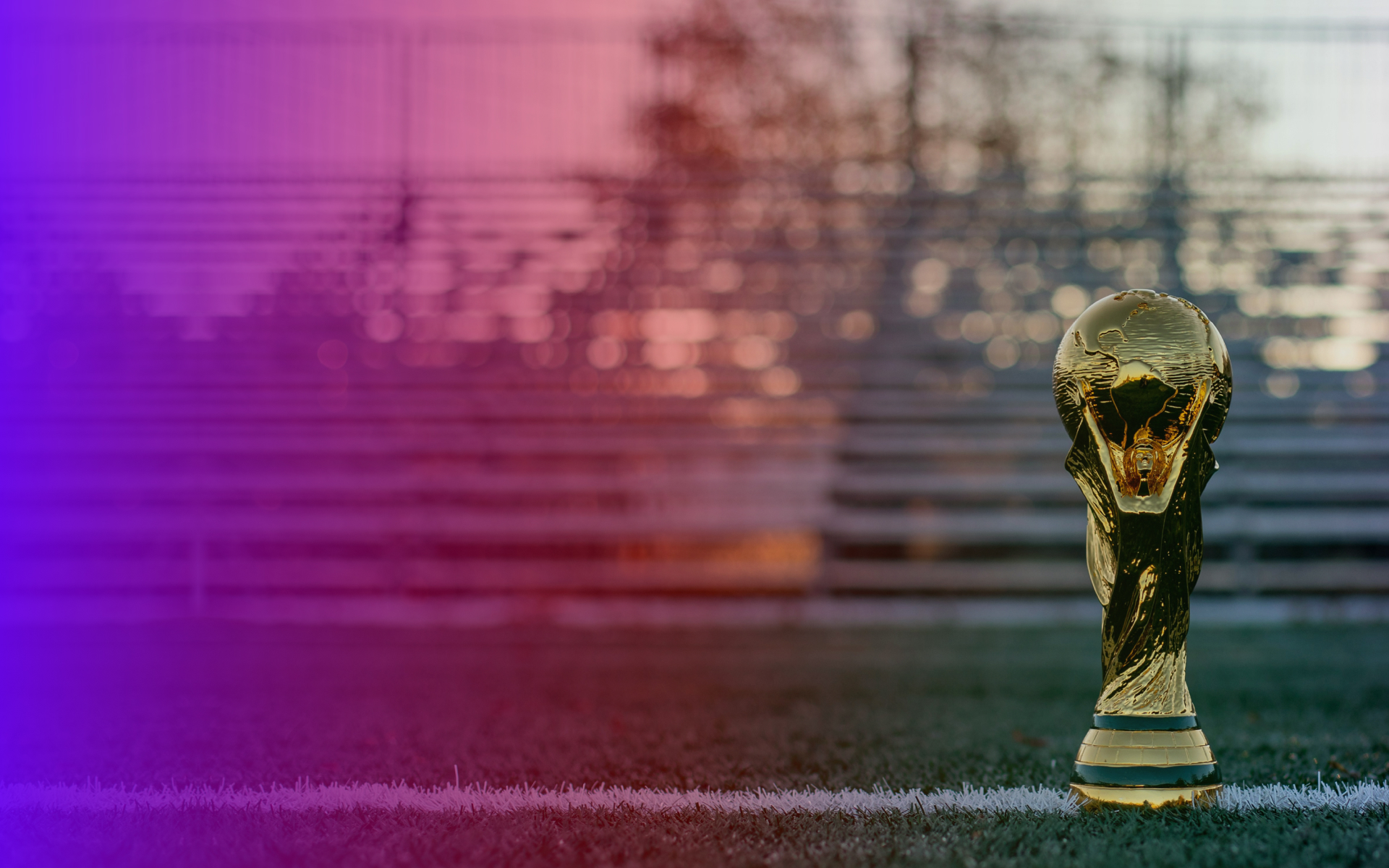 FIFA World Cup trophy on a pitch at dusk